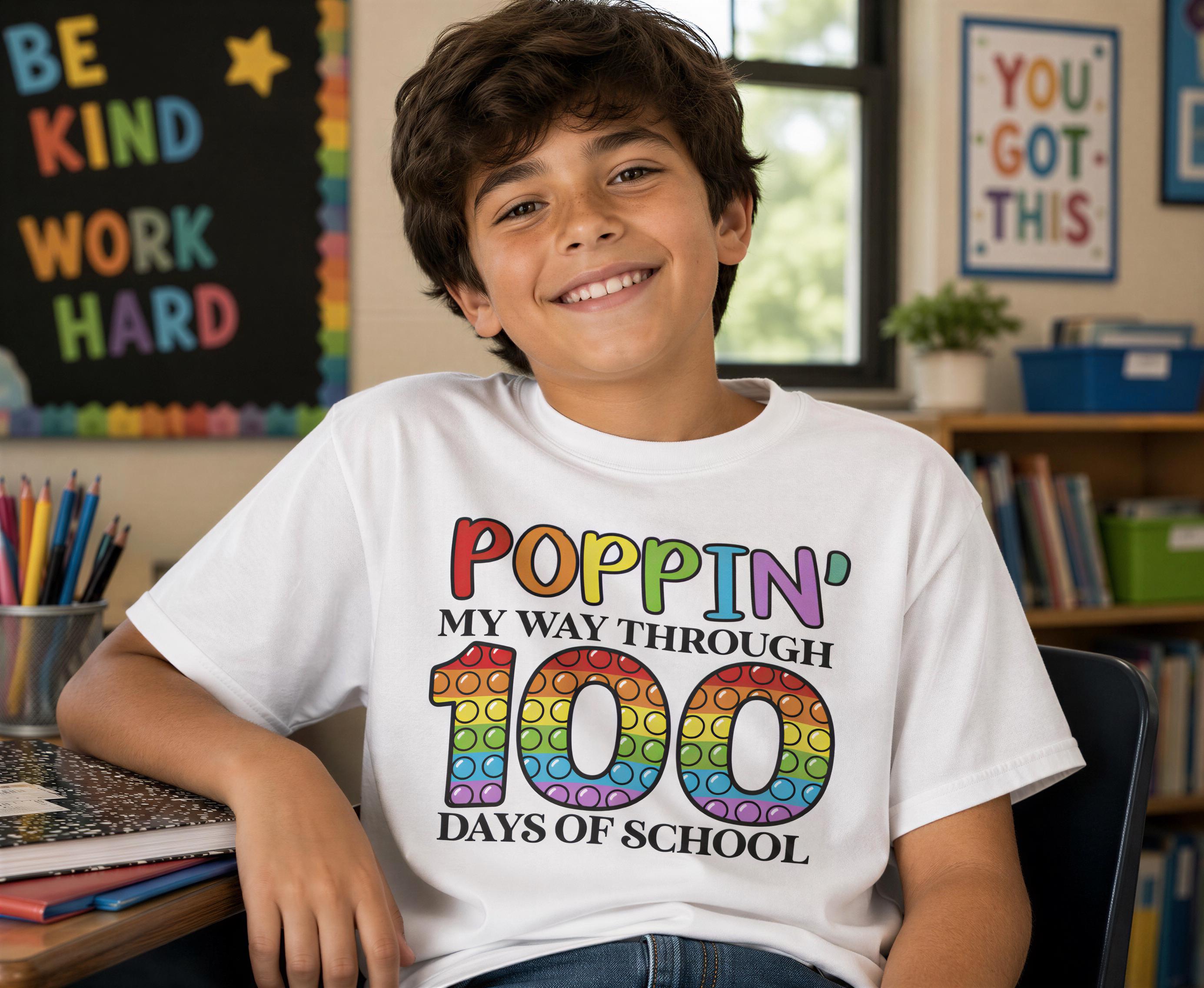A young boy wearing a white t-shirt with a colorful graphic and text, smiling at the camera.
