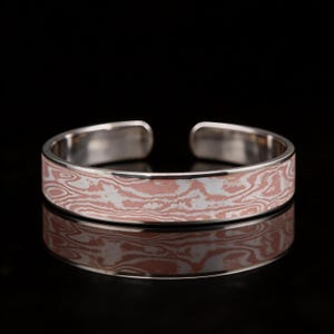 May include: A set of three ceramic mugs with a speckled, matte finish in cream, light brown, and dark brown. Each mug has a simple, minimalist design, ideal for tea or coffee.