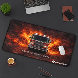 May include: A rectangular mousepad featuring a red fire truck emerging from flames. The mousepad has the words "HONOR • COURAGE • SERVICE" and the Madmatco logo. A computer mouse is on the right side of the mousepad.