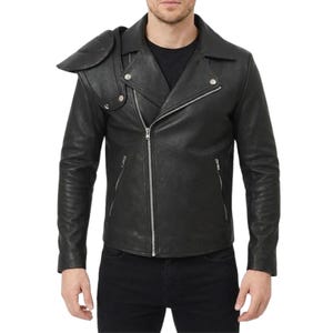 May include: Black leather jacket with an asymmetrical zipper closure and a unique shoulder pad design. The jacket features a classic biker style with a notched collar, zippered pockets, and a fitted silhouette. The jacket is worn with black pants.