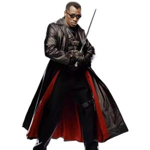 May include: A person wearing a black leather trench coat with a red lining, black pants, and sunglasses, holding a sword. The coat has a long, flowing design.