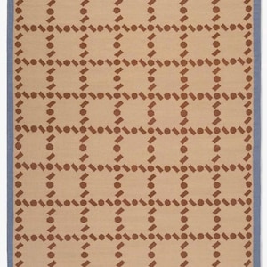 Puede incluir: Alfombra rectangular con un patr&oacute;n geom&eacute;trico repetitivo. La alfombra presenta un fondo beige con una cuadr&iacute;cula de formas marrones y un borde azul. El dise&ntilde;o es sim&eacute;trico y moderno.