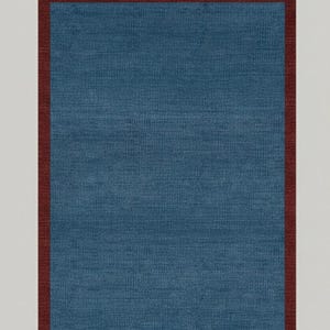 Puede incluir: Una alfombra rectangular con un centro azul y un borde rojo oscuro. La alfombra tiene una apariencia texturizada, lo que sugiere una construcci&oacute;n tejida o de tela. La paleta de colores es simple y elegante, adecuada para varios estilos de dise&ntilde;o de interiores.