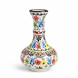 Könnte beinhalten: Eine weiße Keramikvase mit bauchigem Körper und schlankem Hals. Die Vase ist mit einem farbenfrohen Blumenmuster in Rot, Gelb, Blau und Grün verziert, das schwarz umrandet ist. Der Rand ist schwarz.