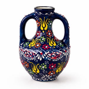 Könnte beinhalten: Eine dunkelblaue Keramikvase mit zwei Henkeln, verziert mit bunten Blumen- und abstrakten Mustern in Rot, Gelb, Weiß und Grün. Die Vase hat eine glänzende Oberfläche und einen weißen Innenraum.