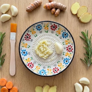 Traditional handmade ceramic plate with garlic grater design