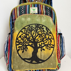 Può includere: Uno zaino colorato con un disegno dell'albero della vita. Lo zaino presenta un pannello centrale con una grafica di albero nero su sfondo giallo e verde. La borsa ha diversi motivi a righe colorate e il testo "Himalayan Hemp THC Free".