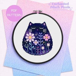 May include: A cross stitch pattern in a black circular hoop featuring a dark blue cat silhouette filled with pixelated pink, purple, and white flowers and stems. The text PDF PATTERN appears in a pink circle, and Enchanted Peach Pixels is visible.