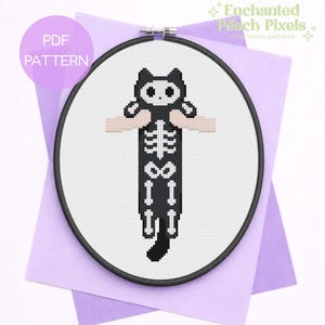 Può includere: Un modello a punto croce con un disegno di scheletro di gatto nero. Il gatto è in un telaio a punto croce, con il testo "PDF PATTERN" e "Enchanted Peach Pixels" visibili. Lo sfondo è viola chiaro.