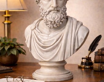 Könnte beinhalten: Eine weiße Büste eines bärtigen Mannes in klassischer Kleidung. Die Skulptur steht auf einem Sockel. Ein Schreibtisch mit Lampe, Büchern und Schreibutensilien im Hintergrund.