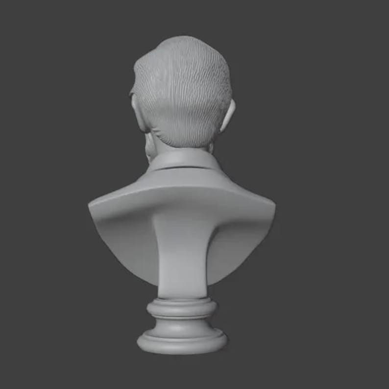 May include: A gray bust sculpture depicting the back of a person's head and shoulders. The sculpture features detailed hair and a collared shirt. The bust is mounted on a pedestal base, and the background is a solid gray.