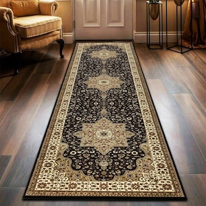 May include: A long, rectangular rug with an ornate, traditional design. The rug features a dark brown background with beige and cream-colored floral patterns and borders. The rug is placed on a hardwood floor.