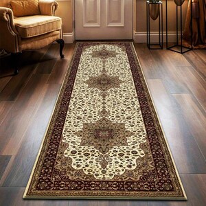 May include: A long, rectangular rug with an intricate floral pattern in cream, burgundy, and gold tones. The rug features a central medallion design and a detailed border, suitable for a hallway or entryway.