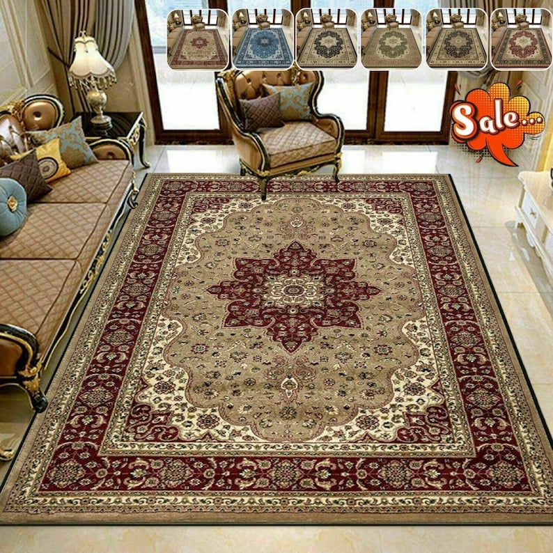 May include: A large rectangular area rug with an ornate floral design in beige, burgundy, and cream. The rug features a central medallion and a detailed border. Several smaller rugs are displayed above the main rug, showcasing different color variations.
