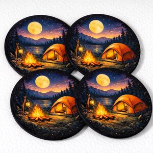 May include: Four round coasters with a camping scene design. Each coaster shows an orange tent, campfire, and full moon over a lake and mountains. The coasters have a dark blue and black background.