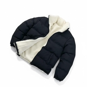 May include: Black puffer jacket with a white, fluffy interior. The jacket has a zip closure and a pocket. The jacket is designed to be reversible, offering two distinct styles. The jacket is a winter outerwear item.