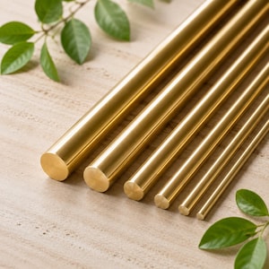 Op de afbeelding: Een set van zes gepolijste messing staven gerangschikt in een parallelle rij, afnemend in diameter van links naar rechts. Elke staaf heeft een glad, cilindrisch oppervlak met een metallic gouden afwerking en platte, ronde uiteinden.