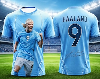 May include: A light blue football shirt featuring a graphic of a player in a matching kit on the front. The back displays the name HAALAND, the number 9, and a signature. The design includes white accents and a subtle pattern on the sleeves.