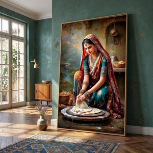 May include: A framed artwork depicts a woman in traditional Indian attire, kneading dough. The painting features a vibrant color palette with reds, oranges, and greens. The artwork is displayed in a room with a rug and wooden furniture.