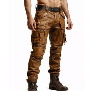 May include: Brown leather cargo trousers featuring multiple pockets and zips. The fitted design is complemented by a black belt and brown boots. The leather has a distressed finish.