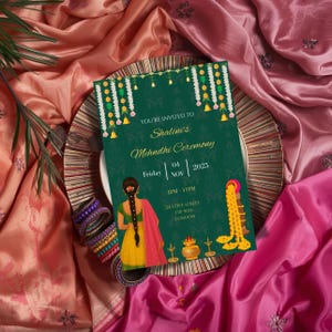 Puede incluir: Una tarjeta de invitación verde para la ceremonia Mehndi de Shalini, con decoraciones florales y campanas. La tarjeta incluye la fecha, hora y lugar: 24 Love Street, Londres. La tarjeta está sobre un plato decorativo, con pulseras coloridas y tela drapeada.