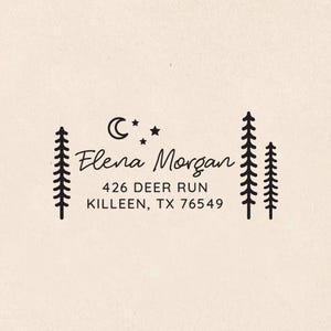 May include: A black ink rubber stamp design on a light beige background featuring the text Elena Morgan, 426 DEER RUN, KILLEEN, TX 76549. The design includes a crescent moon, three small stars, and three stylized pine trees on the sides.