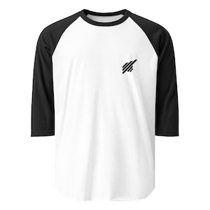 Könnte beinhalten: Weißes und schwarzes Baseball-Shirt mit Dreiviertelärmeln. Das Shirt hat einen schwarzen Rundhalsausschnitt und eine kleine schwarze Grafik auf der Brust. Die Ärmel sind schwarz, und der Körper des Shirts ist weiß.