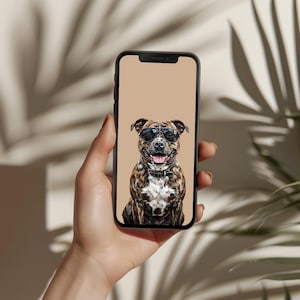 May include: A smartphone displays a digital illustration of a brown and white dog wearing sunglasses. The dog has a collar and is smiling with its tongue out. The phone is held in a hand against a neutral background.