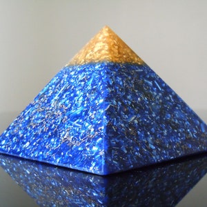 May include: A blue and gold pyramid made of resin with a sparkly, glittery finish.