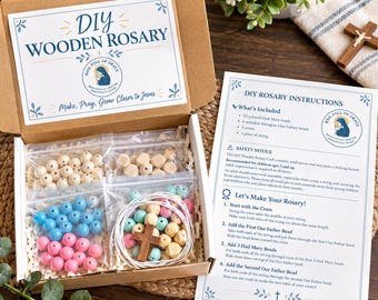 May include: A DIY wooden rosary craft kit in a cardboard box containing bags of light blue, pink, and natural wooden beads, a wooden cross, and string. The box lid and an included instruction sheet feature the text DIY WOODEN ROSARY.