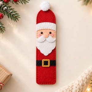 May include: A rectangular felt bookmark featuring a Santa Claus design with a red hat, a white pom-pom, a peach-coloured face, a white beard, and a black belt with a yellow buckle. The bookmark is constructed from red felt with visible stitching.