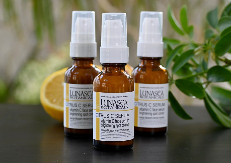 K&ouml;nnte beinhalten: Drei bernsteinfarbene Glasflaschen mit wei&szlig;en Pumpenk&ouml;pfen, gef&uuml;llt mit einem Serum mit Zitrusduft. Die Flaschen sind mit "LUNASEA BOTANICALS CITRUS C SERUM vitamin C face serum brightening spot correct orange blossom+lemon+turmeric" beschriftet.