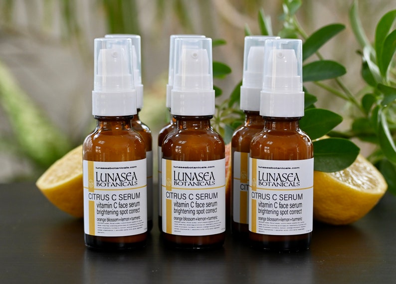 K&ouml;nnte beinhalten: F&uuml;nf bernsteinfarbene Glasflaschen mit wei&szlig;en Pumpenk&ouml;pfen, gef&uuml;llt mit einem Serum auf Citrusbasis. Die Flaschen sind mit "LUNASEA BOTANICALS CITRUS C SERUM vitamin C face serum brightening spot correct orange blossom+lemon+turmeric" beschriftet.