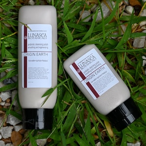 Puede incluir: Dos tubos blancos de pulido limpiador probi&oacute;tico con tapas negras. Los tubos est&aacute;n etiquetados con "LUNASEA BOTANICALS" y "ORIGIN EARTH" con los ingredientes enumerados a continuaci&oacute;n. Los tubos est&aacute;n sobre un lecho de hierba verde.