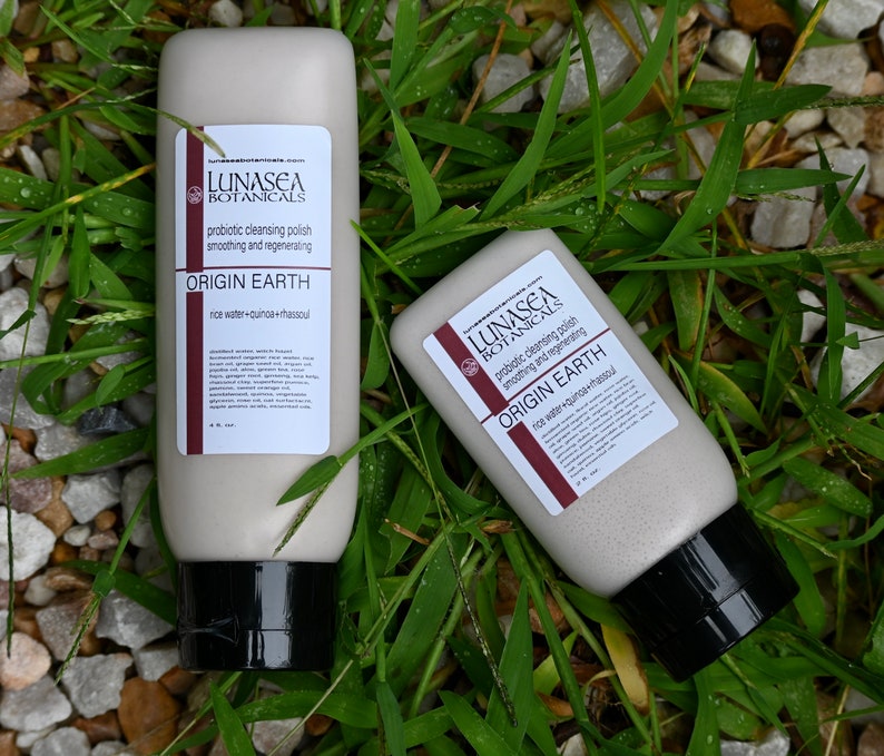 Puede incluir: Dos tubos blancos de pulido limpiador probi&oacute;tico con tapas negras. Los tubos est&aacute;n etiquetados con "LUNASEA BOTANICALS" y "ORIGIN EARTH" con los ingredientes enumerados a continuaci&oacute;n. Los tubos est&aacute;n sobre un lecho de hierba verde.