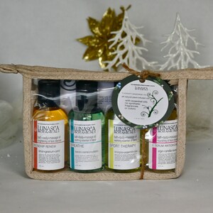 May include: A set of four small bottles of bath and body massage oil in a beige canvas bag. The bottles are labeled with the brand name "LUNASEA BOTANICALS" and the names of the oils: "ROSEHIP RENEW", "BREATHE", "SPORT THERAPY", and "SERUM ANTIOXIDANT".