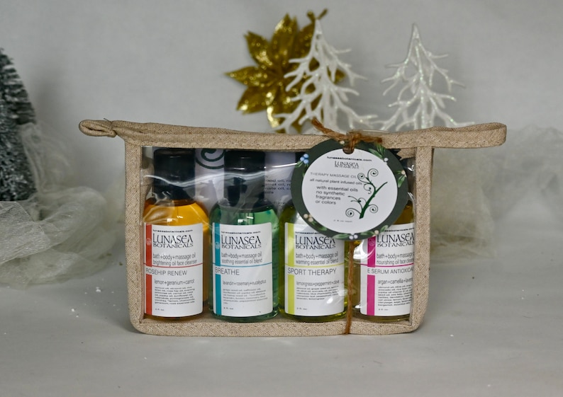 May include: A set of four small bottles of bath and body massage oil in a beige canvas bag. The bottles are labeled with the brand name "LUNASEA BOTANICALS" and the names of the oils: "ROSEHIP RENEW", "BREATHE", "SPORT THERAPY", and "SERUM ANTIOXIDANT".