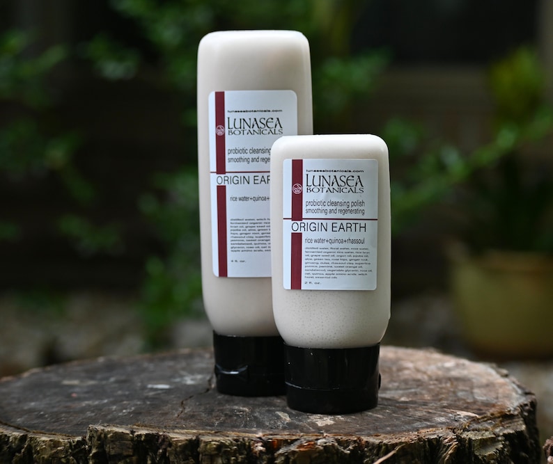 Puede incluir: Dos tubos de pl&aacute;stico blanco de limpiador facial con etiquetas marrones. Las etiquetas dicen "LUNASEA BOTANICALS" y "limpieza probi&oacute;tica" y "ORIGIN EARTH". El tubo m&aacute;s peque&ntilde;o dice "agua de arroz + quinoa + hassoul".