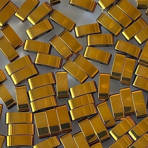 Op de afbeelding: Een verzameling kleine, rechthoekige, metallic gouden kralen met een glad, reflecterend oppervlak. Elke kraal heeft een uniforme vorm met afgeronde randen, verspreid in een dichte opstelling, met een consistente heldere goudkleur.