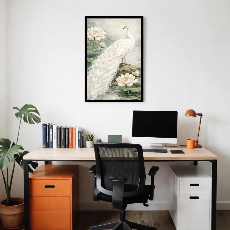 May include: A framed art print depicting a white peacock with a long tail, standing on a rock surrounded by water lilies. The artwork has a soft, light background, creating a calm and elegant feel. The frame is black.