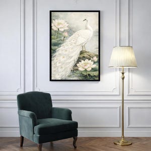May include: A framed art print depicting a white peacock with a long tail, standing on a rock near lotus flowers. The artwork has a soft, watercolour style with a serene, natural theme. The frame is black.