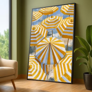 May include: A framed vertical wall art print featuring a repeating pattern of multiple beach umbrellas with alternating yellow and white stripes. The umbrellas are depicted from a top-down perspective against a soft, light blue sky background.