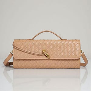 May include: A tan-coloured, rectangular handbag with a woven pattern. It features a top handle, a detachable shoulder strap, and a gold-coloured clasp. The bag is made of a soft, leather-like material.