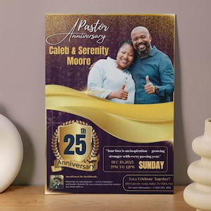 May include: A framed poster for a Pastor's 25th Anniversary, featuring a photo of a smiling couple. The design includes gold and purple accents, with text that reads "Caleb & Serenity Moore" and event details.