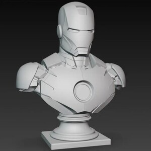 K&ouml;nnte beinhalten: Graue B&uuml;ste von Iron Man, die den Helm und die R&uuml;stung der Figur zeigt. Die B&uuml;ste ist auf einem Sockel montiert und zeigt das ikonische Aussehen des Superhelden. Die Skulptur ist eine detaillierte Darstellung der Marvel Comics-Figur.