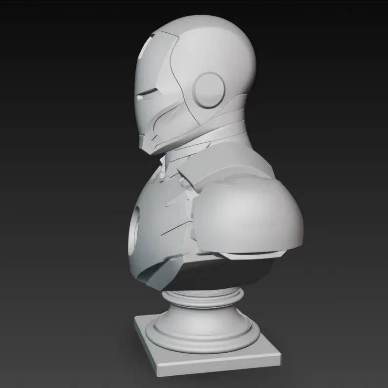 K&ouml;nnte beinhalten: Eine graue B&uuml;ste von Iron Man, die das ikonische Helm- und R&uuml;stungsdesign zeigt. Die Skulptur ist auf einem Sockel montiert und zeigt die erkennbaren Merkmale und die Form der Figur.