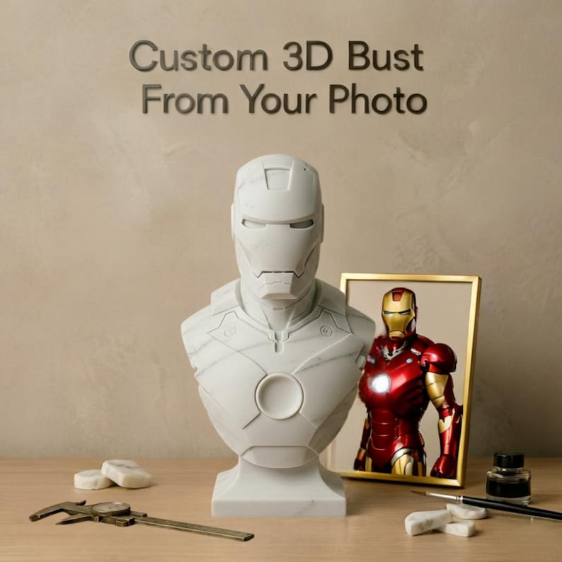 K&ouml;nnte beinhalten: Eine wei&szlig;e 3D-B&uuml;ste von Iron Man mit dem Text "Custom 3D Bust From Your Photo" dar&uuml;ber. Rechts befindet sich ein gerahmtes Bild von Iron Man. Ein Messschieber, eine Tintenflasche und Pinsel befinden sich auf der Holzoberfl&auml;che.
