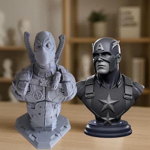 K&ouml;nnte beinhalten: Zwei graue B&uuml;sten von Comicfiguren. Eine ist Deadpool, mit Schwertern auf dem R&uuml;cken. Die andere ist Captain America, mit einem Stern auf der Brust und dem Buchstaben "A" auf dem Helm. Beide stehen auf einer Holzoberfl&auml;che.