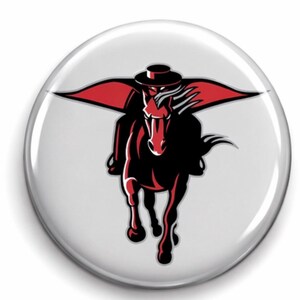 May include: A white button featuring a black horse and rider with a red cape and hat. The horse is galloping forward, and the rider is wearing a hat. The design is a stylized illustration.