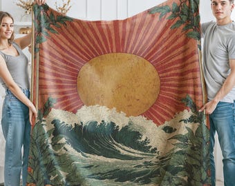 May include: A large, rectangular blanket featuring a vintage-style illustration. The design includes a large sun with radiating lines, ocean waves, and foliage with oranges. The color palette is warm, with shades of orange, brown, and green.